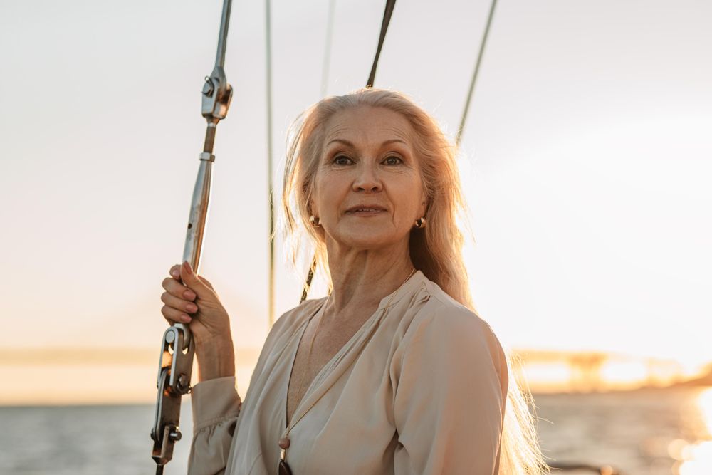Portrait of elegant older woman on a sailboat at dusk