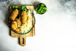 Baked potato, spinach and cabbage salad on marble counter with space for text