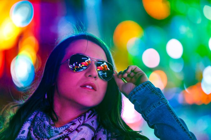 Stylish young woman near illumination on street