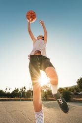 Energetic kid jumping while throwing ball