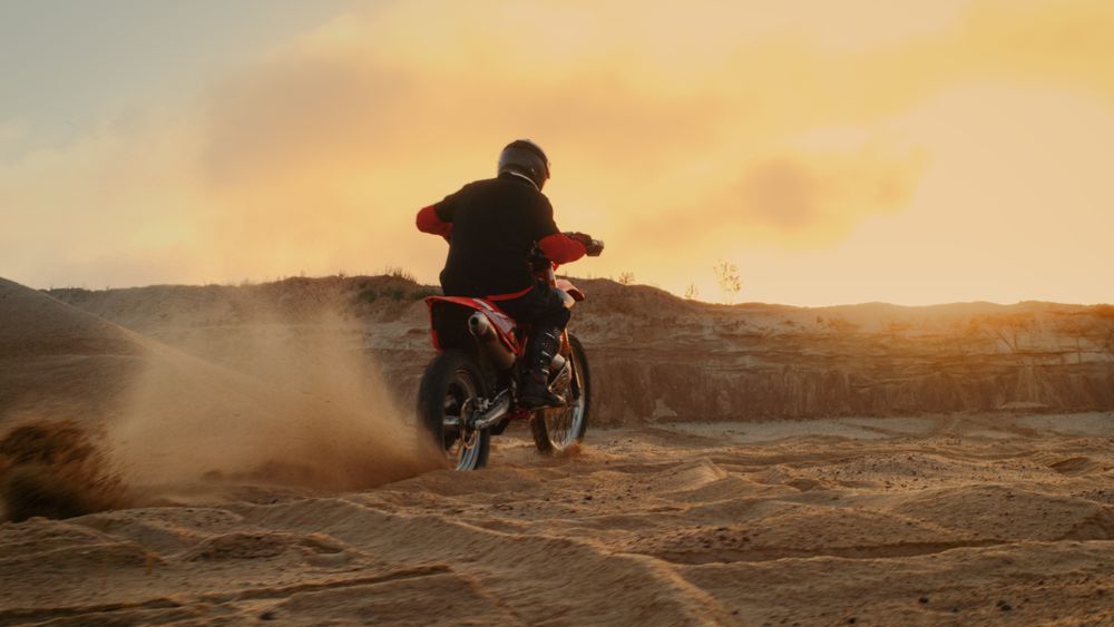 Professional Bike Rider Blasts-off on His FMX Motorcycle Over Sandy Off-Road Track.