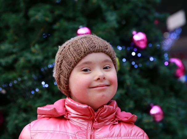 Happy child standing in front of christmas tree