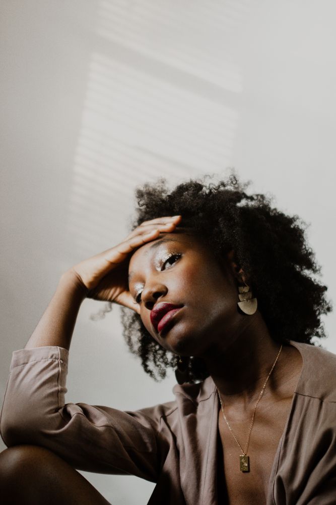 Portrait of woman in brown blazer against light wall