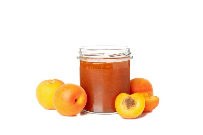 Glass jar with apricot jam isolated on blank background