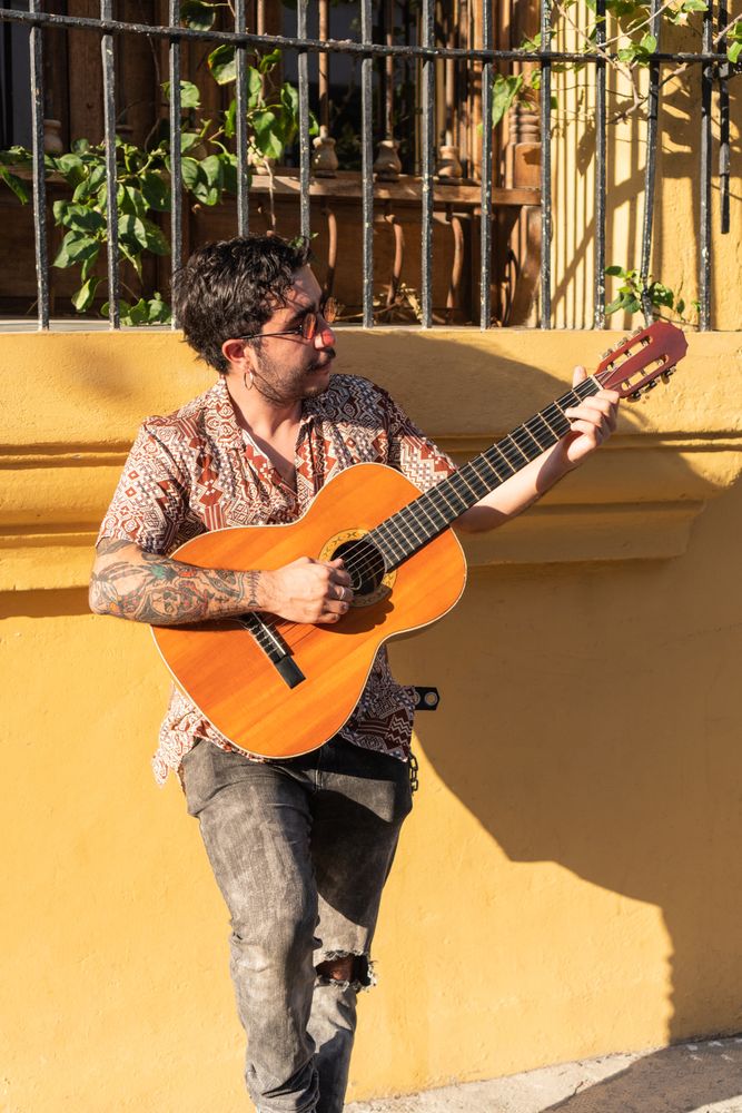 Street Musician playing guitar on the city streets at sunset
