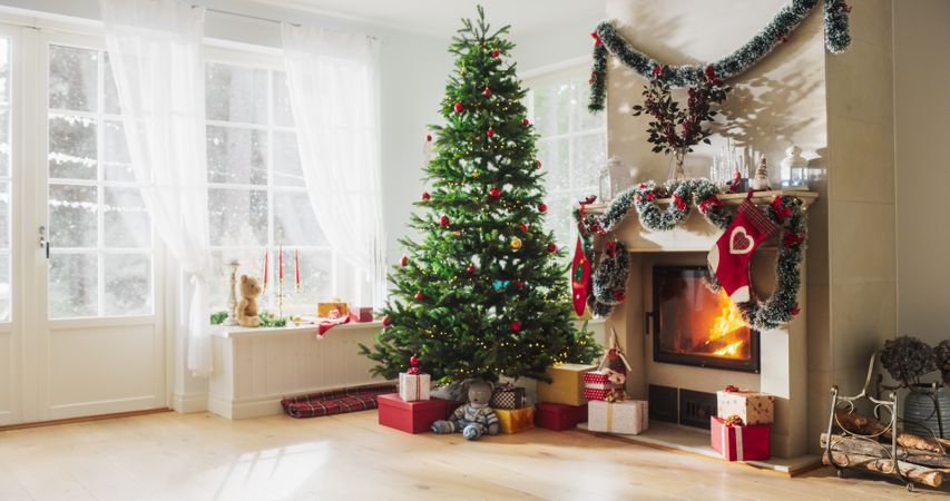 Peaceful Snowy Christmas Morning: Decorated Corner in Modern House with Christmas Tree, Fireplace and Gifts.