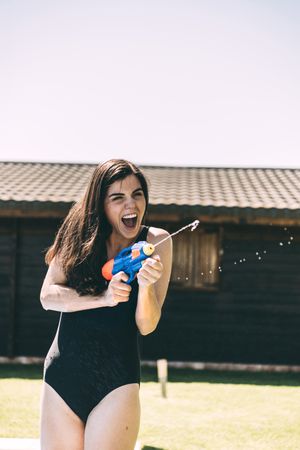 Woman aiming with water-pistol