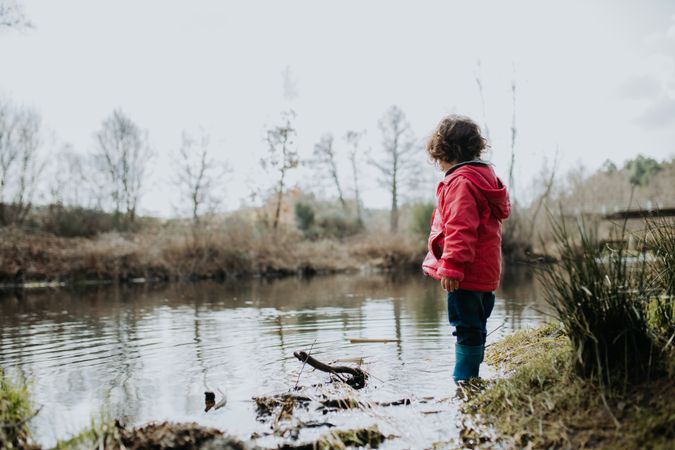 Child looking across a pond