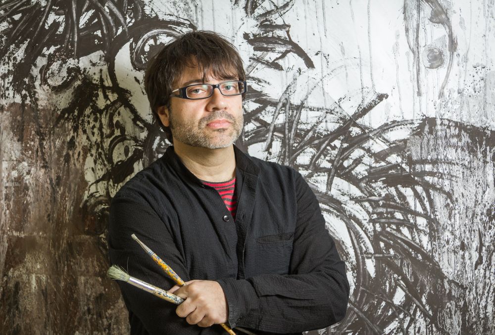 Painter artist posing in front of paint