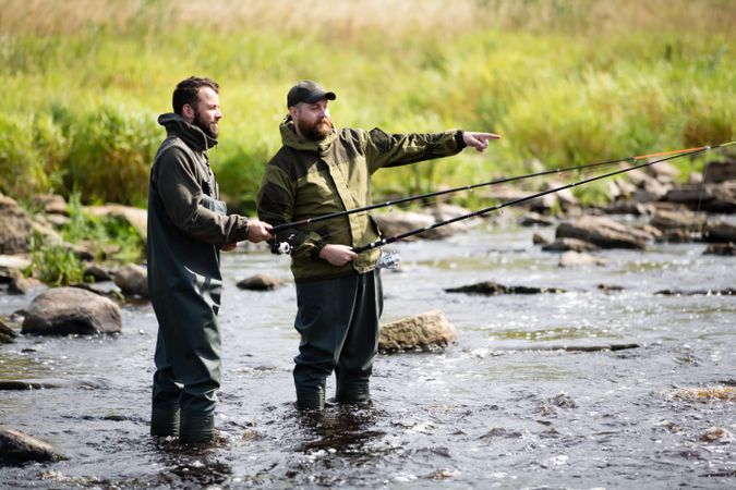 Fishermen in River Pointing Ahead