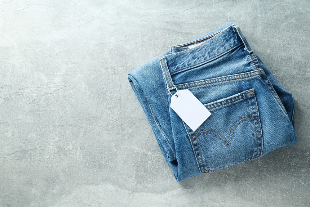 Folded jeans with a tag on a light background
