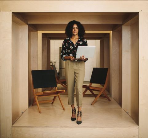 Businesswoman standing with open laptop