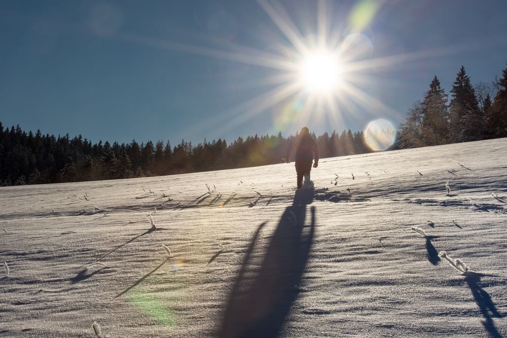 Winter scenery with man climbing mountain through snow in Germany