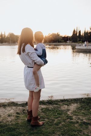 Mother and daughter standing near water