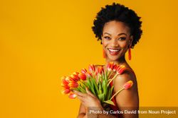 Happy Black woman holding bouquet of tulips 0y2Bq5
