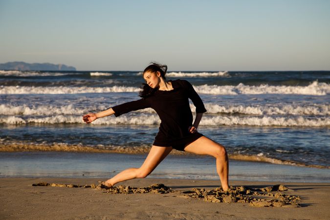 Woman with dancing near water on shore