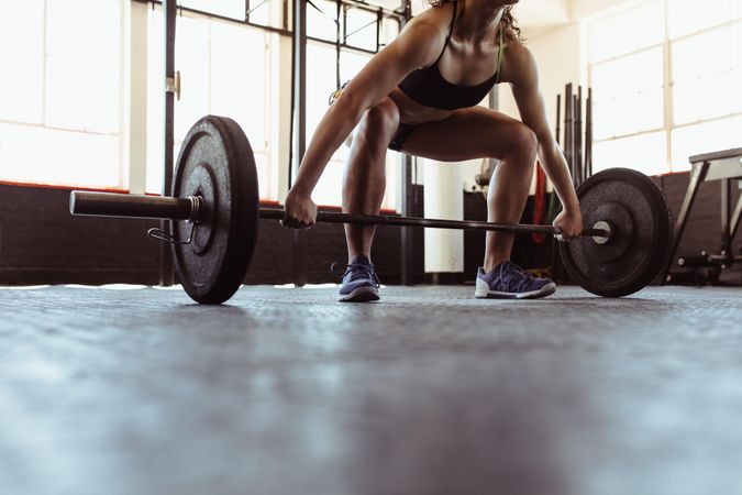 Female athlete working out with weights at cross training gym