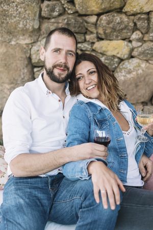 Couple sitting on a terrace while bonding and enjoying a cup of wine