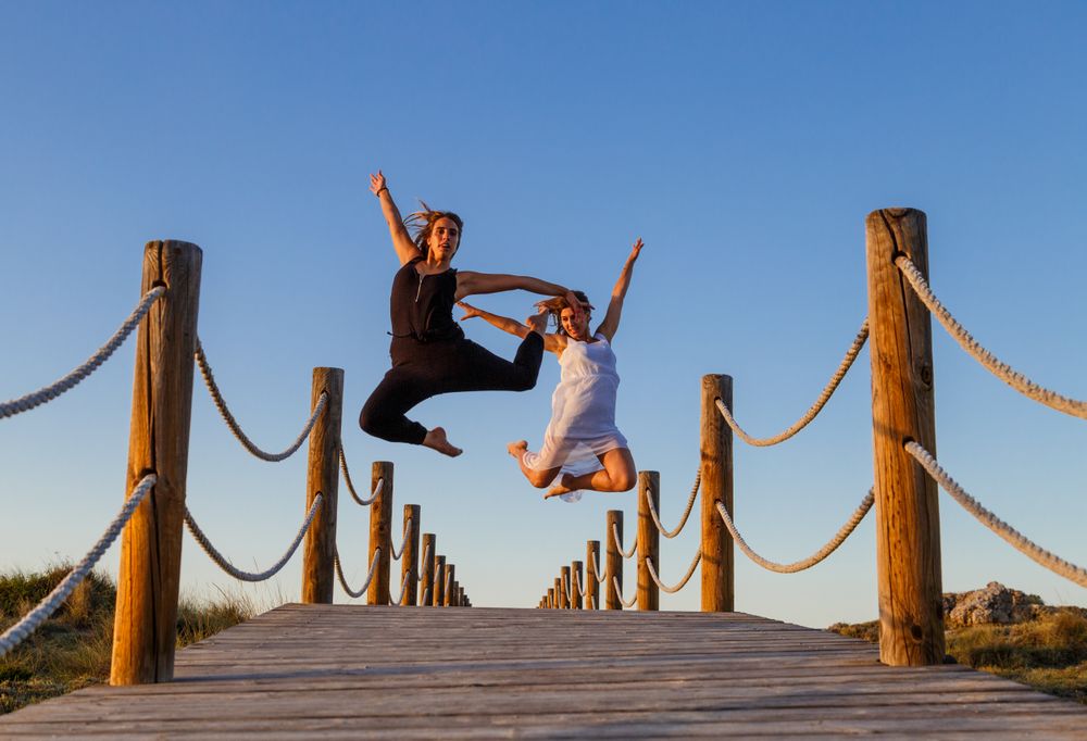 Women posing in air on footbridge