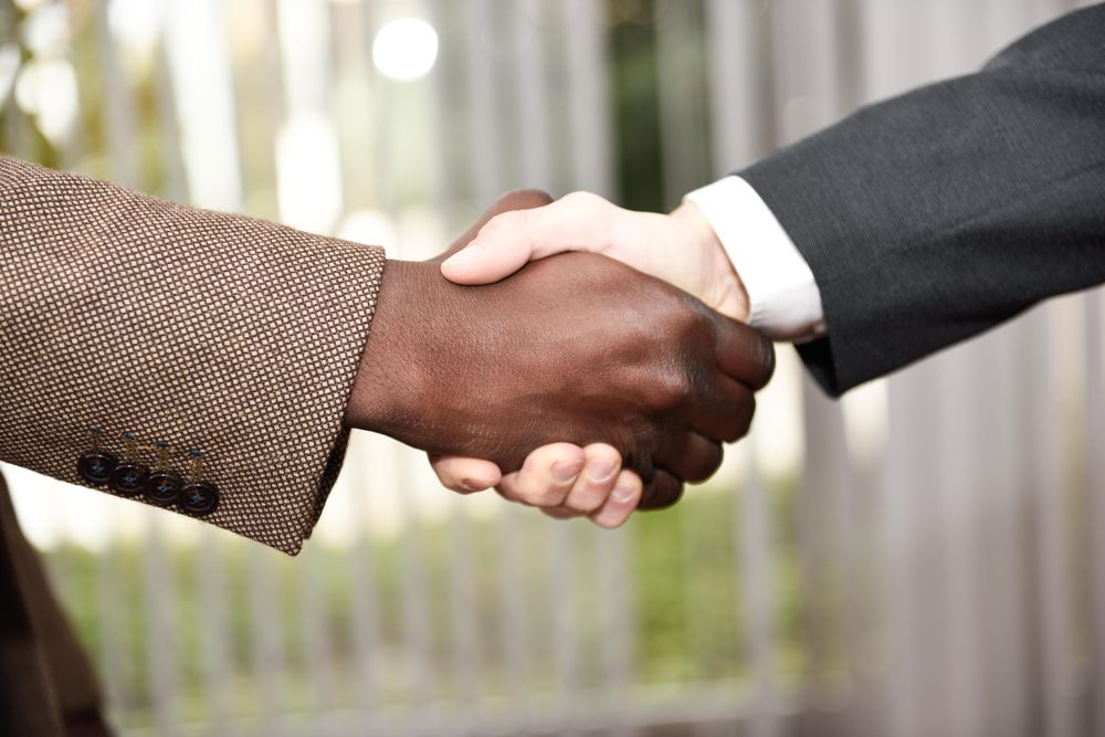 Two men in business suits shaking hands