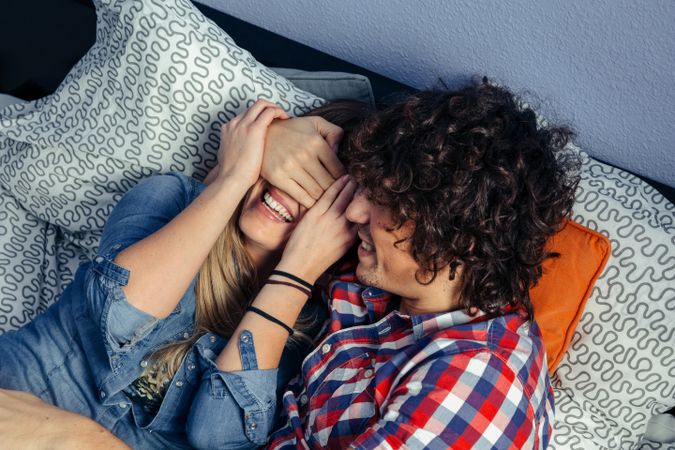 Couple playing and laughing on the bed