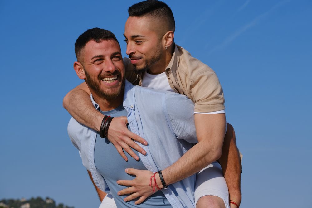 Happy gay couple playing piggyback