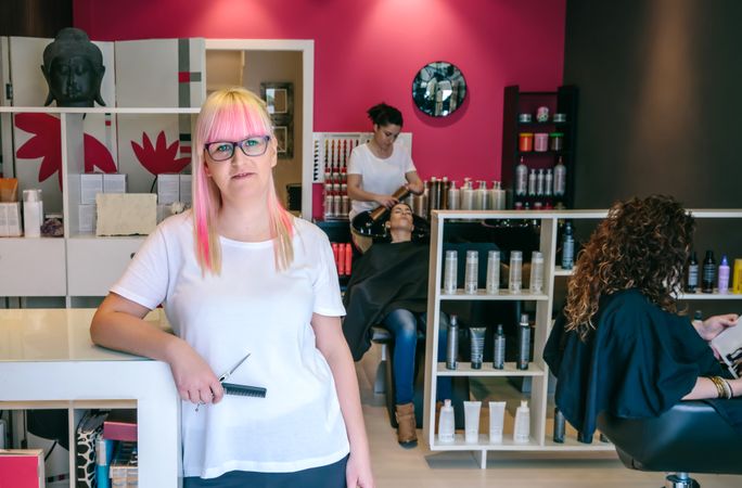 Hairdresser standing in opening of busy salon