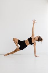 Sportive woman performing yoga pose in room