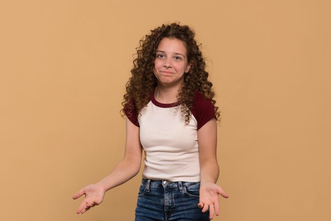 Young girl with shrugging gesture, expressing confusion