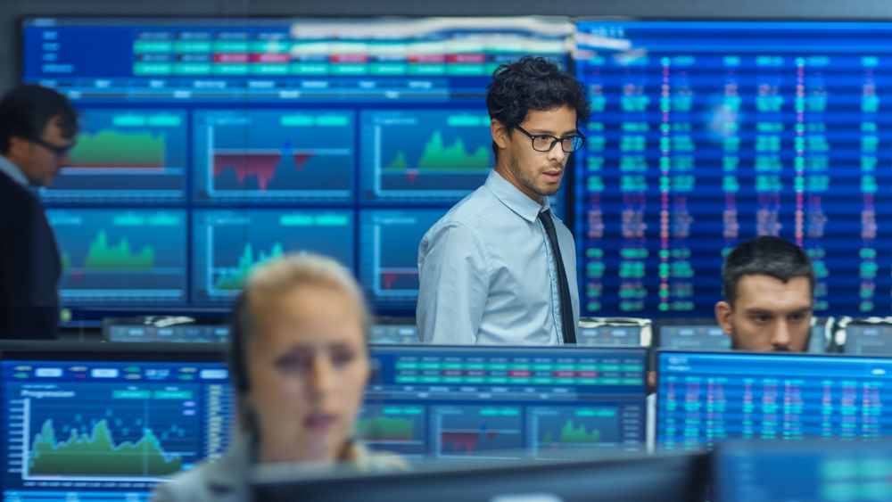 Stock Trader Inspects Others Work and Chat with Other.