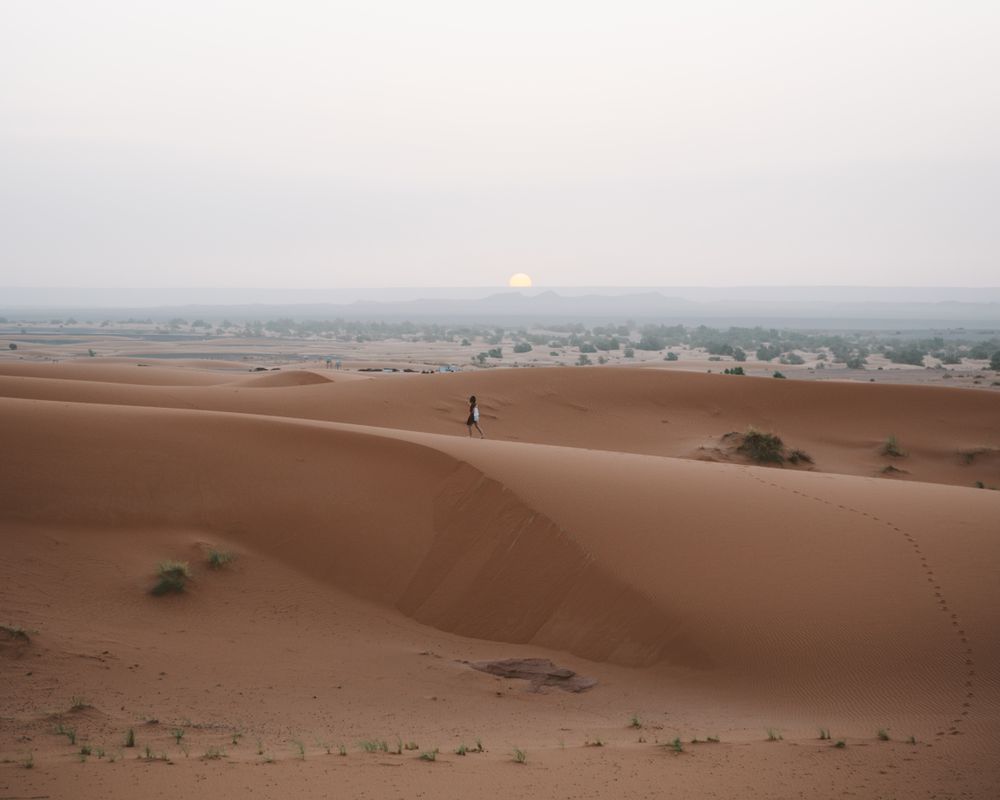 Woman in summer dress walking in desert