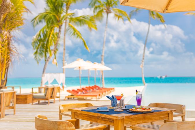 Table set up at a beach resort with pizza and cocktails