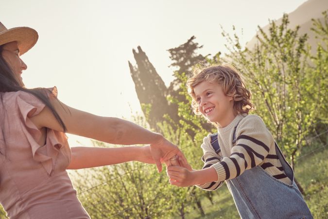 Mother and son holding hands on sunny day