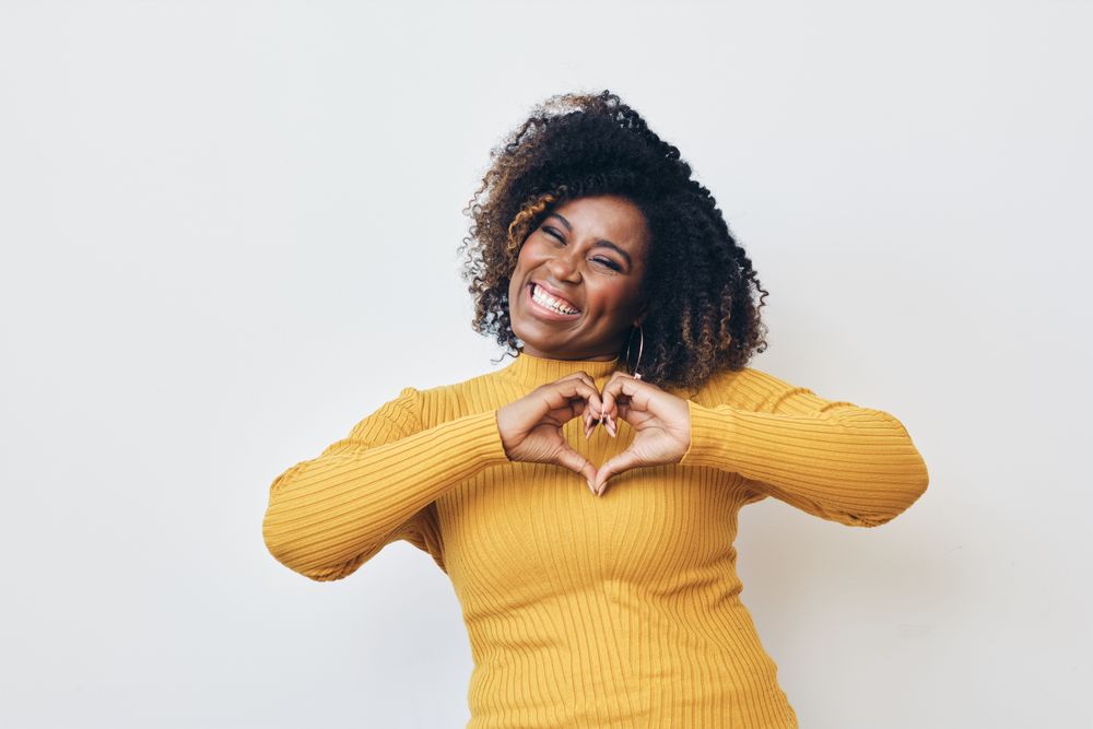Happy woman making heart with hands