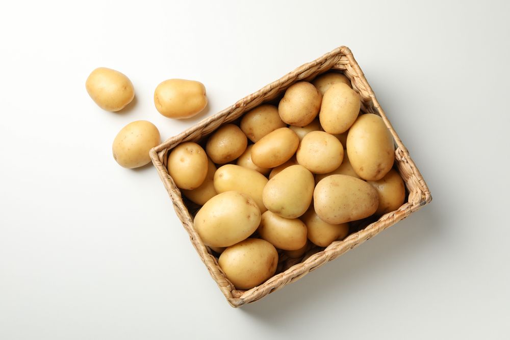 Looking down at wooden box full of potatoes