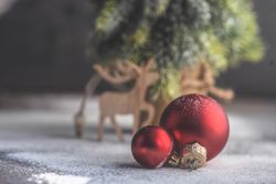 Christmas card concept of red bauble with mini tree in background