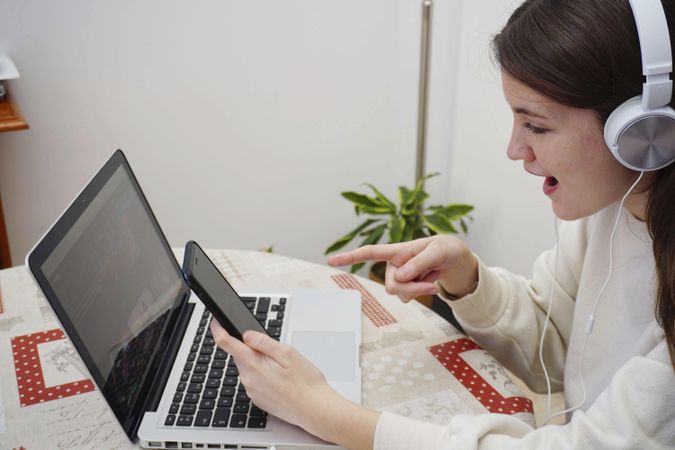 Side view of teenage girl studying online at home