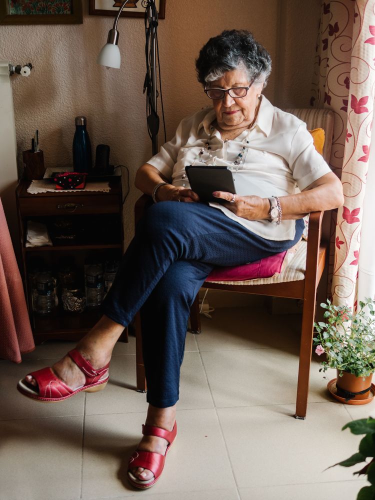 Older female reading e-book at home