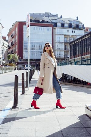 Young happy trendy woman walking in city