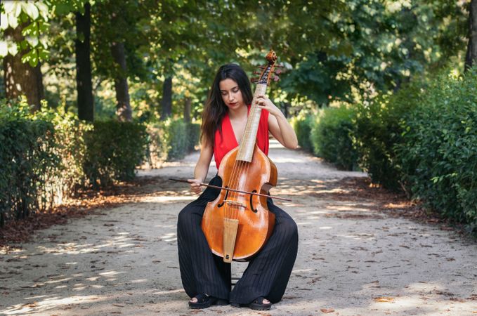 Woman playing the cello in a park.