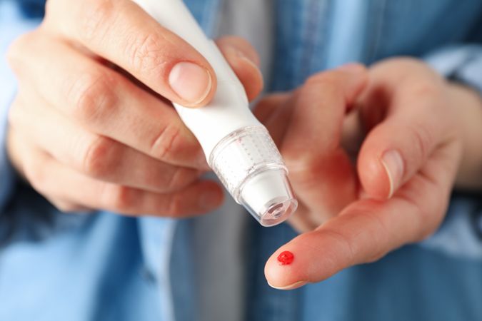 Woman checking blood sugar level, close up
