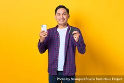 Happy man holding smart phone and wallet bxnOd5