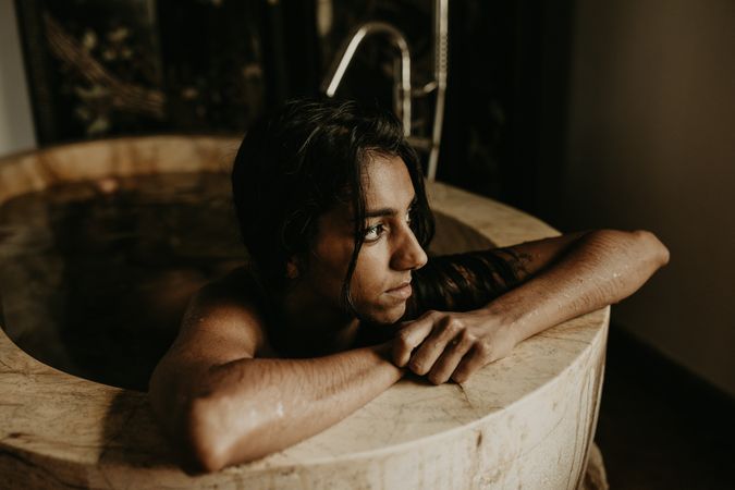 Melancholic Woman sitting and washing in bath