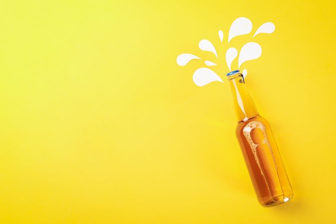 Bottle of beer on yellow background, space for text
