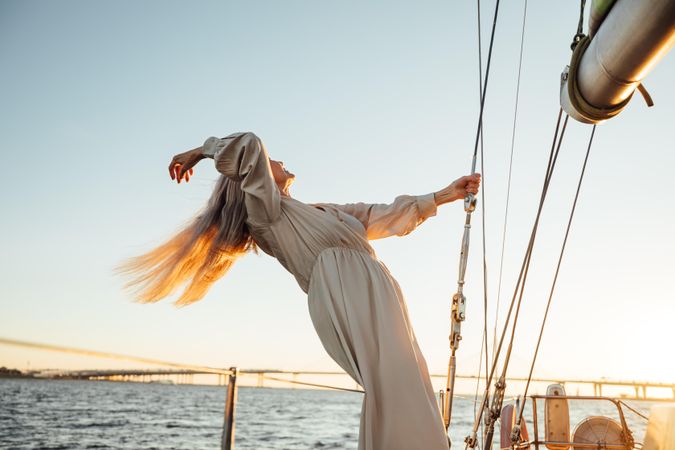 Mature woman leaning back on a sailboat with long hair