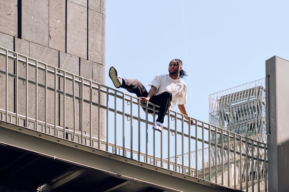 Black male sitting on bridge