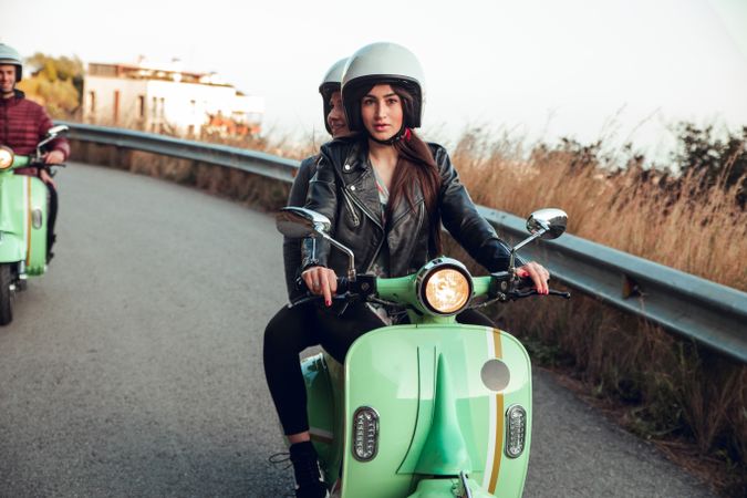 Young people riding motorcycles on city road