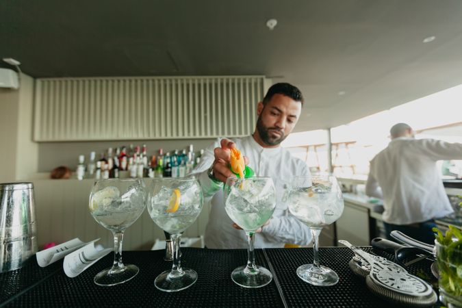 Cheerful Barman preparing alcoholic drinks in a bar.