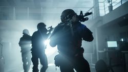 Masked Squad of Armed SWAT Police Officers Move in a Hall of a Dark Seized Office Building with Desks and Computers.