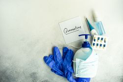 Soap wrapped in facemask with pills, thermometer and latex gloves with copy space